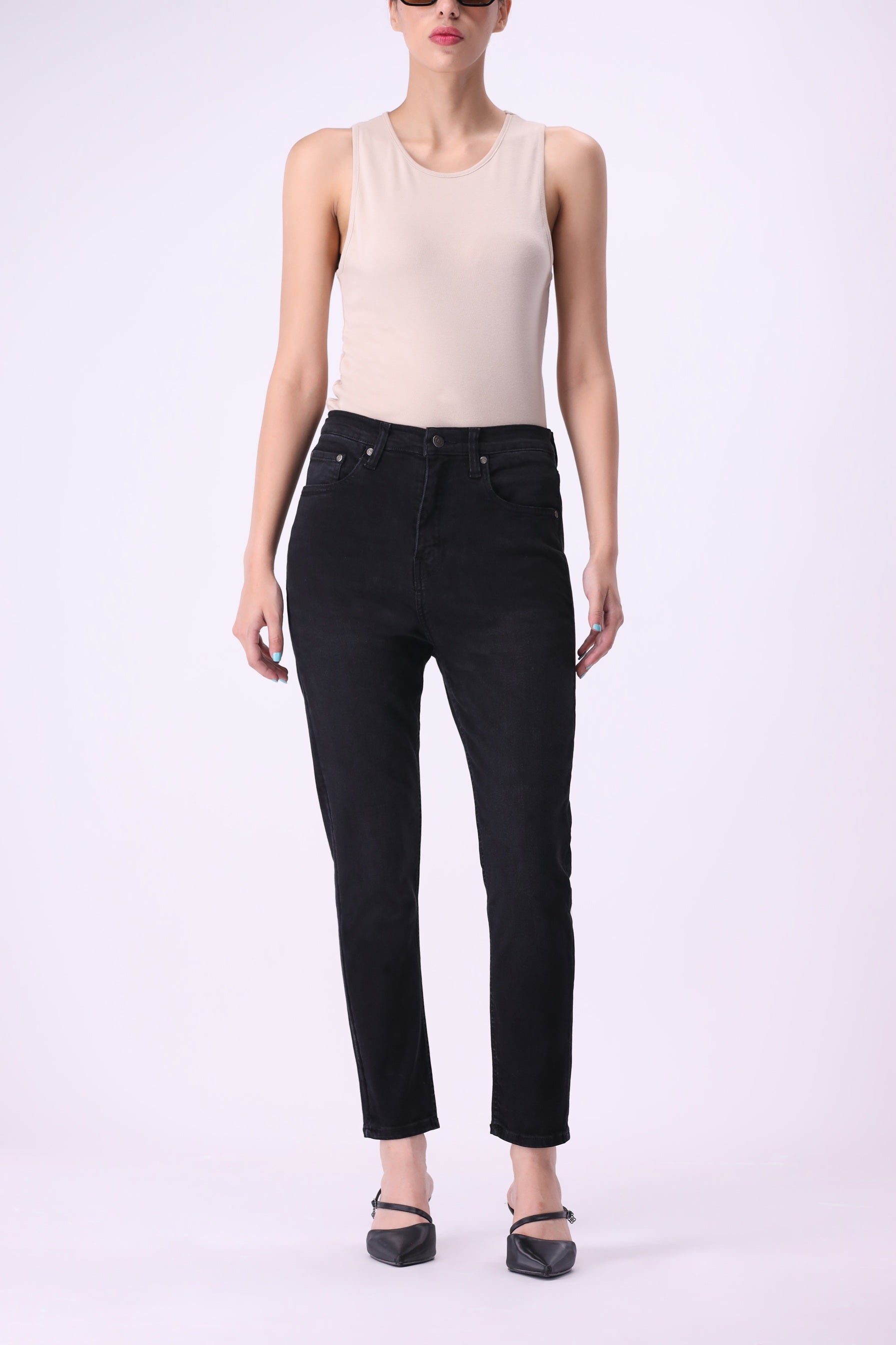 Full front view of women’s Beryoza jeans in black wash, slim tapered fit, paired with a beige tank top.