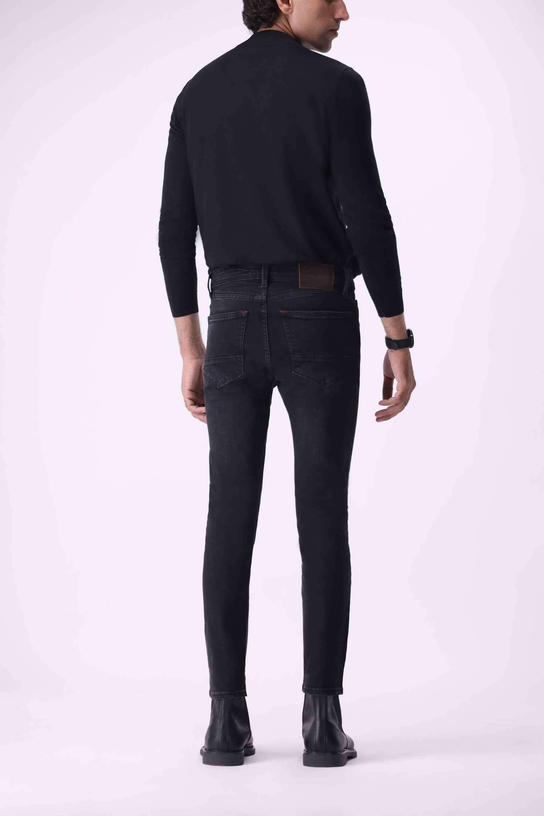 Full back view of Atlas slim-fit black jeans made from 78% organic cotton and 20% recycled cotton.