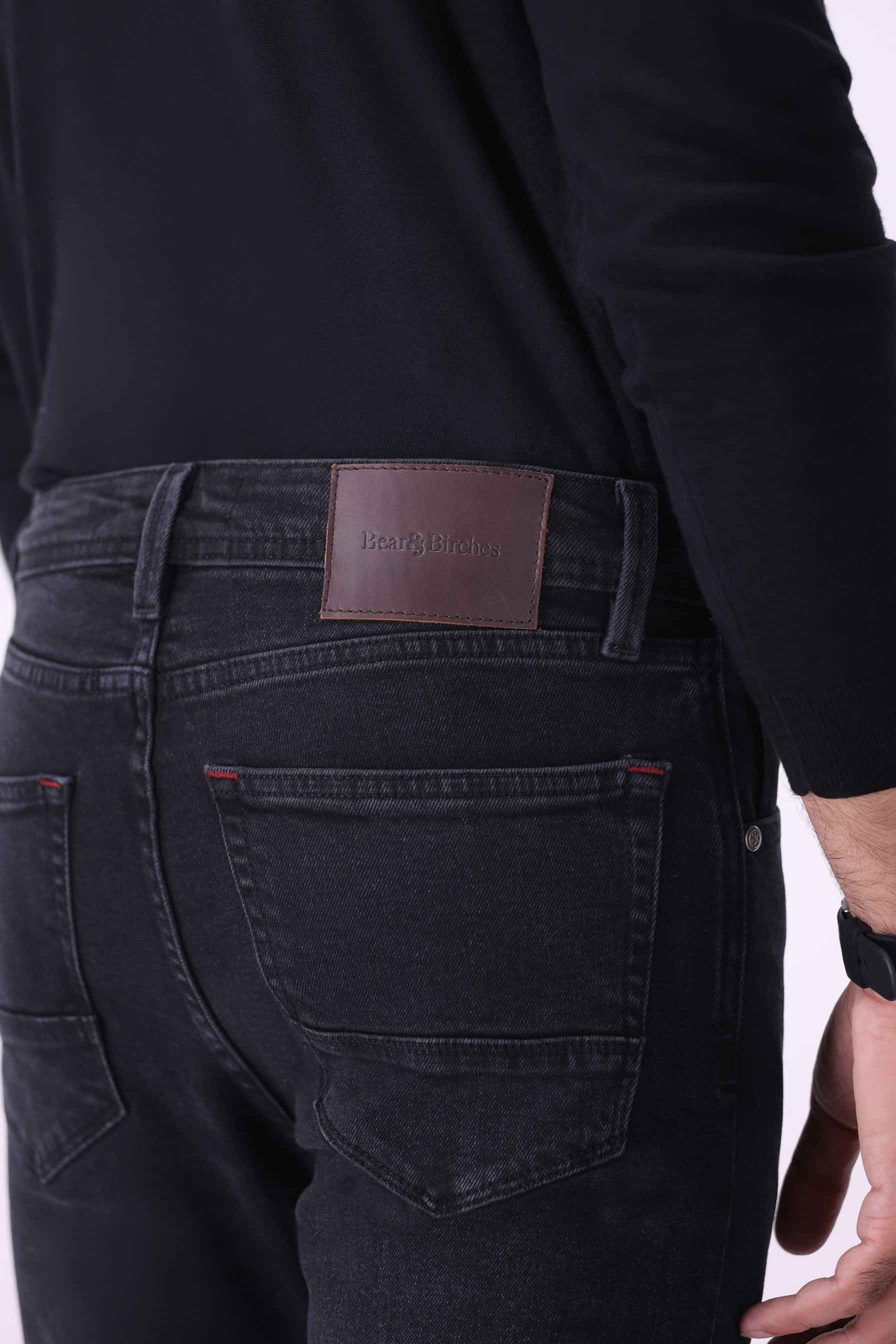 Back view of Atlas men's jeans featuring classic pocket styling and a genuine leather brand patch.