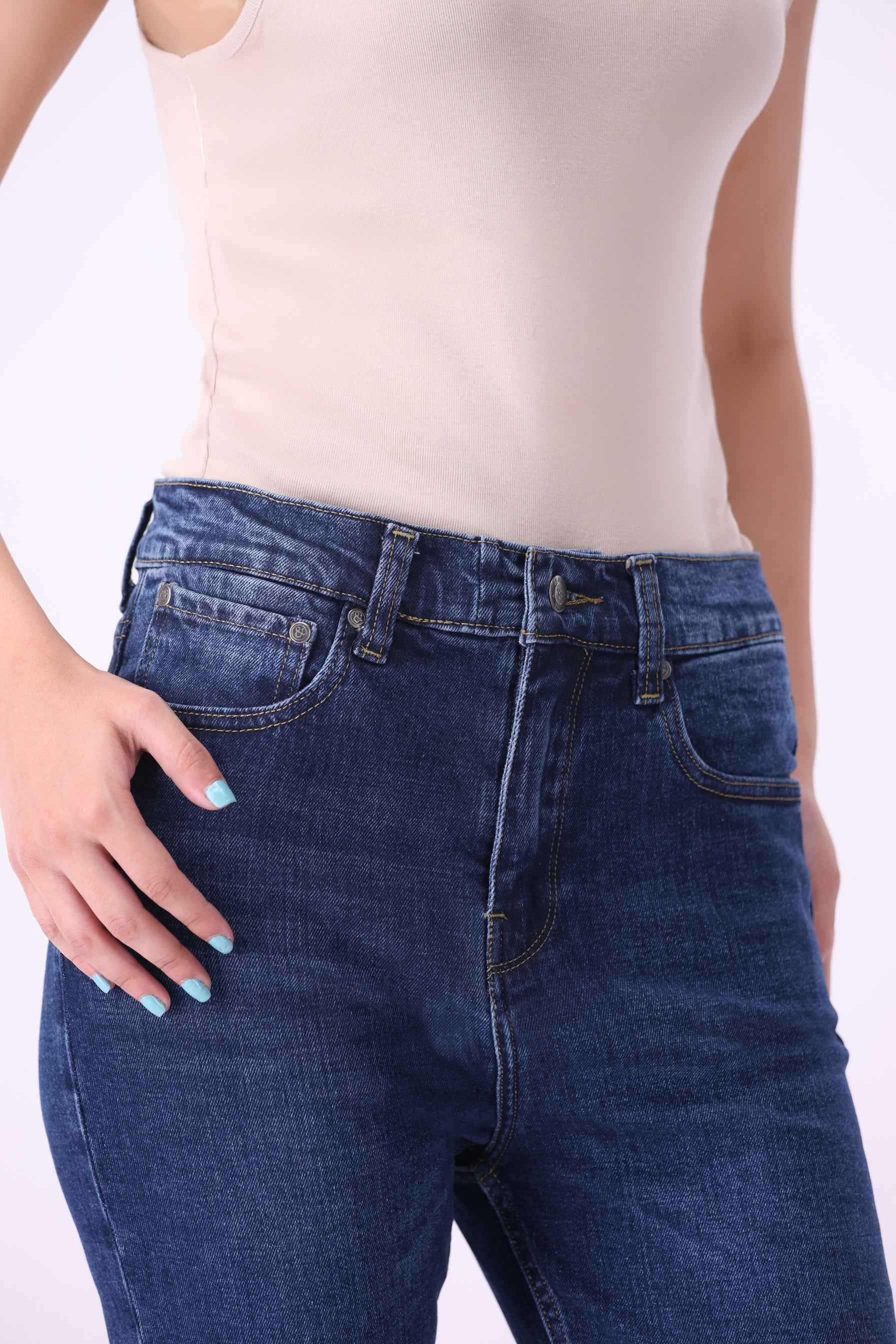 Close-up front view of Beryoza high-rise jeans in Mid Indigo, highlighting the premium sustainable denim texture.