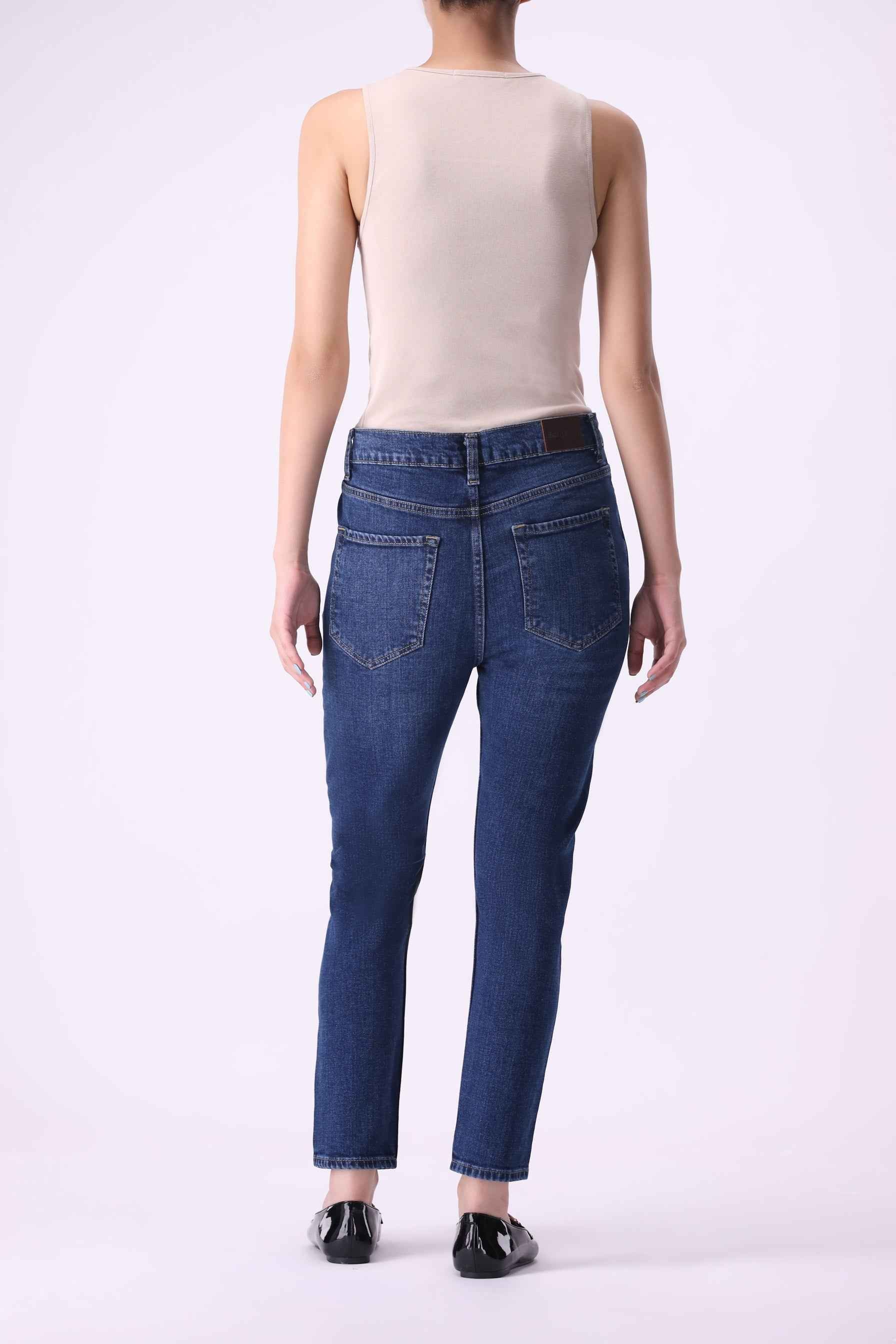 Side profile of Beryoza high-rise skinny jeans in Mid Indigo, showcasing the flattering fit and performance stretch.