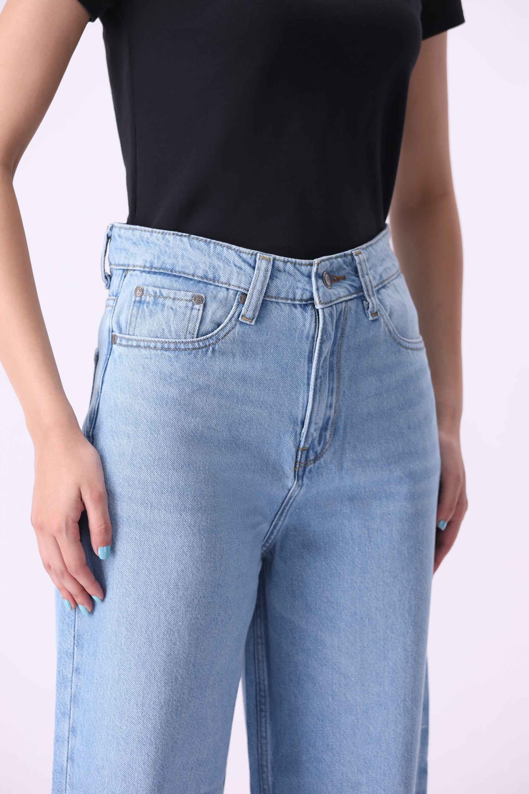 Close-up front view of Noor jeans highlighting the high-rise waistband and premium light-wash denim texture.