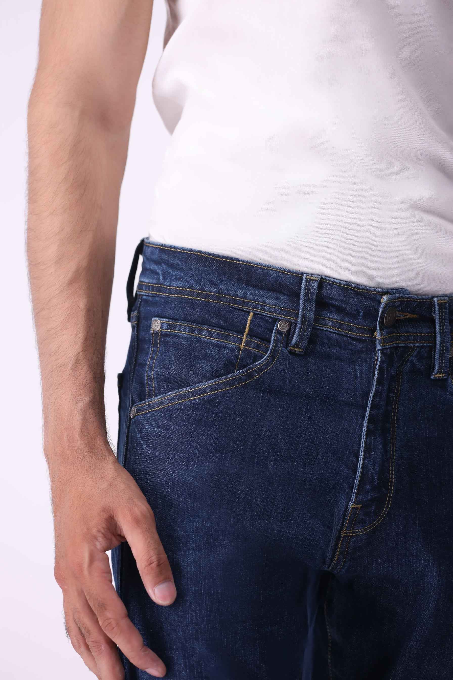 Close-up front view of Ursa indigo jeans highlighting the high-quality sustainable denim and tailored waistband.