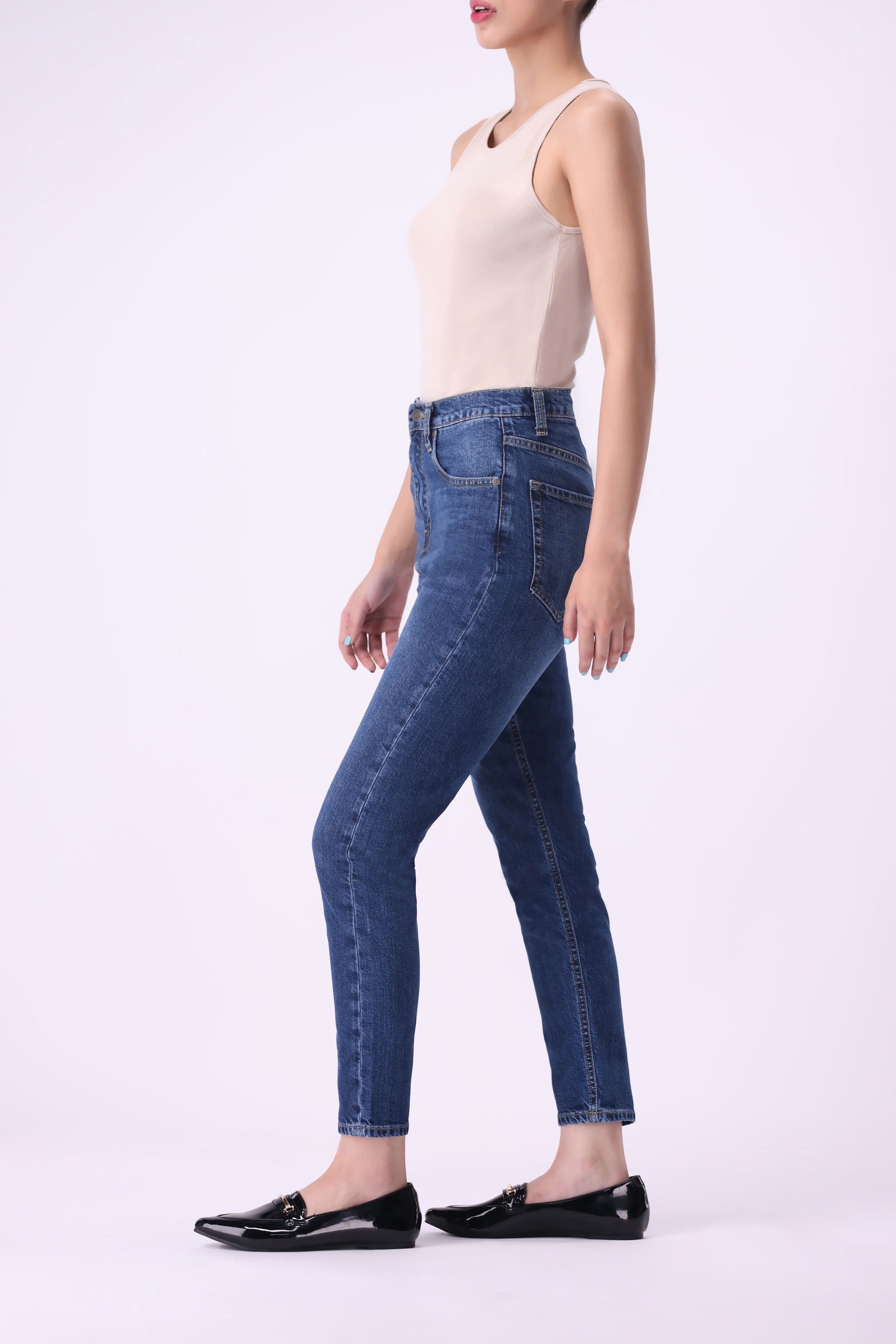 Side view of women’s high-rise skinny jeans in dark indigo denim with slim ankle cut