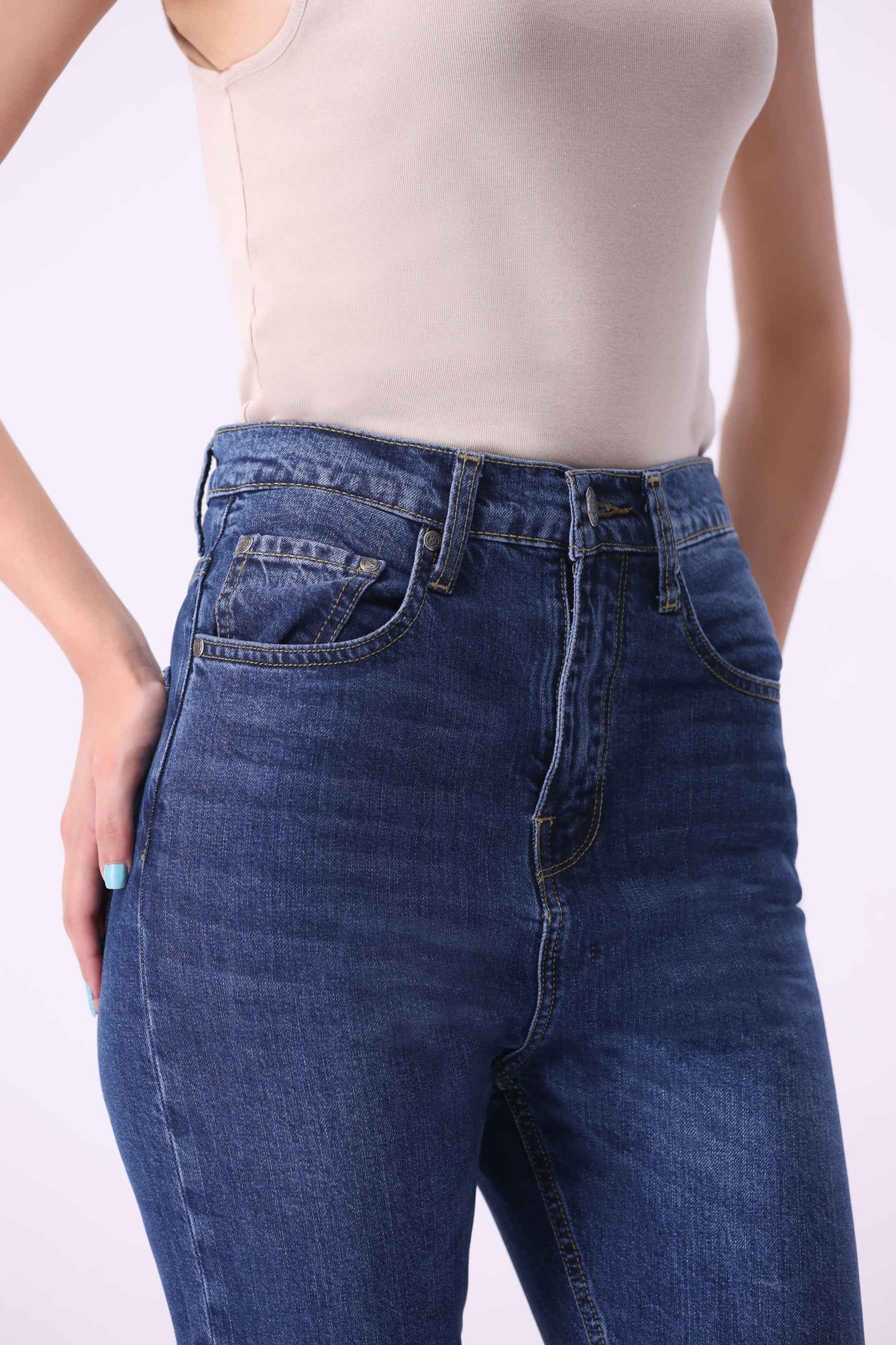 Close-up front view of Abedul high-rise jeans highlighting the sustainable denim texture and premium tailored waistband.