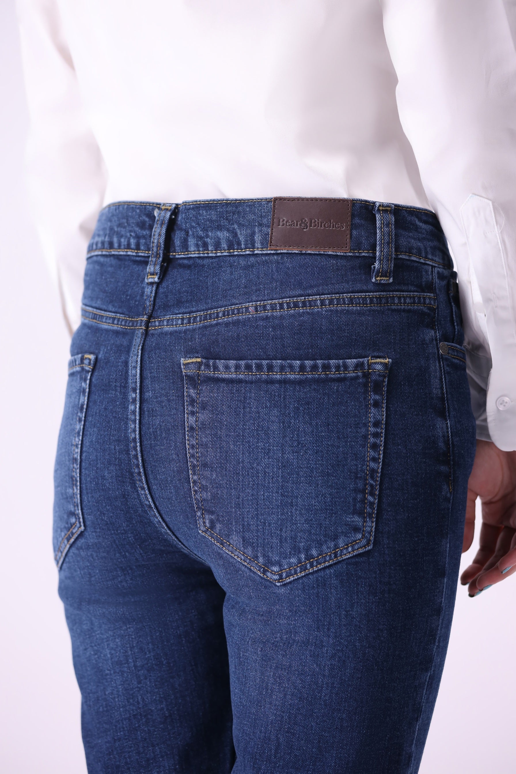 Back pocket detail of women’s Shirikaba dark indigo boyfriend jeans with leather brand patch.