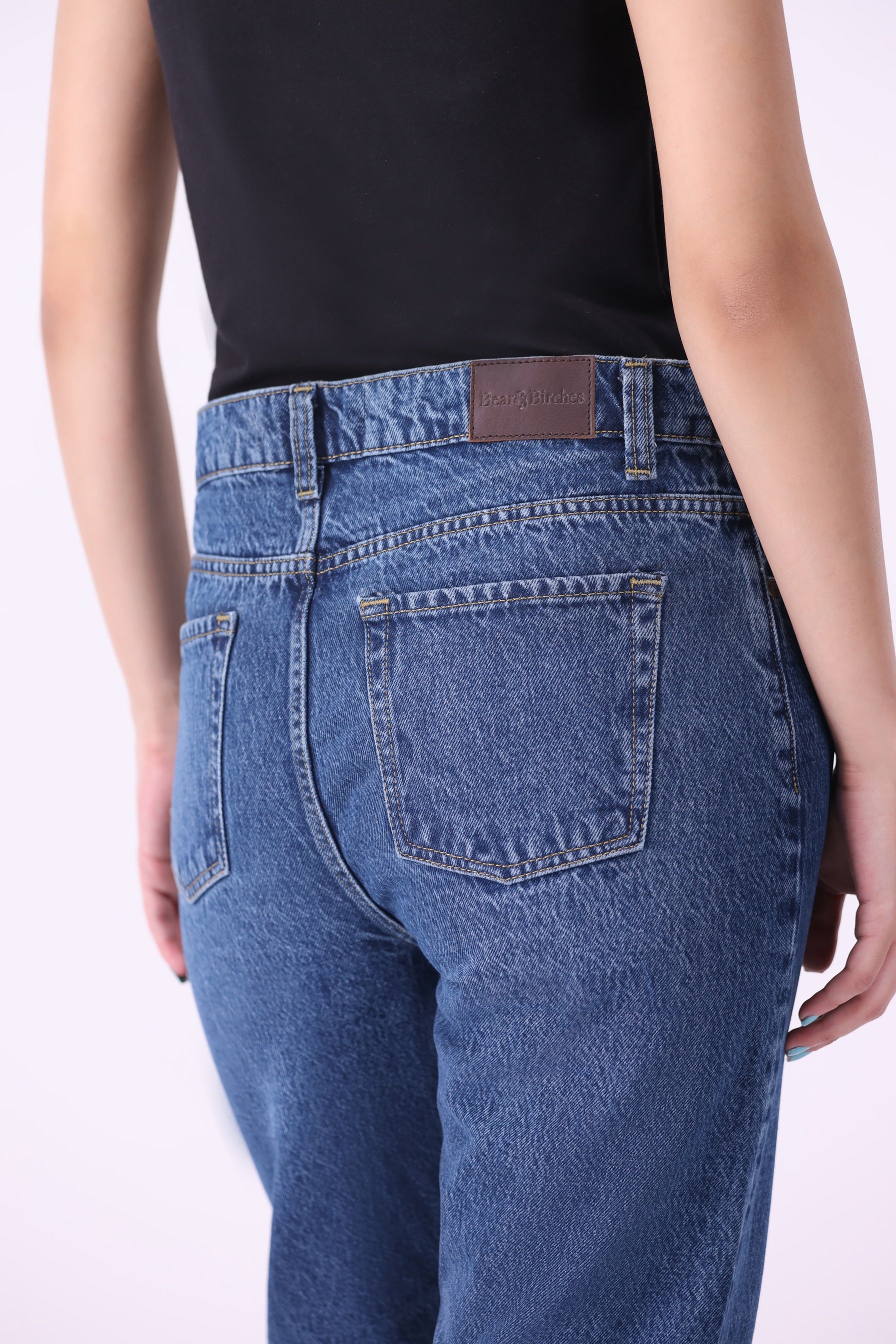 Angled back view of Bear & Birches Koivu women’s slim straight jeans, mid-rise fit, medium blue