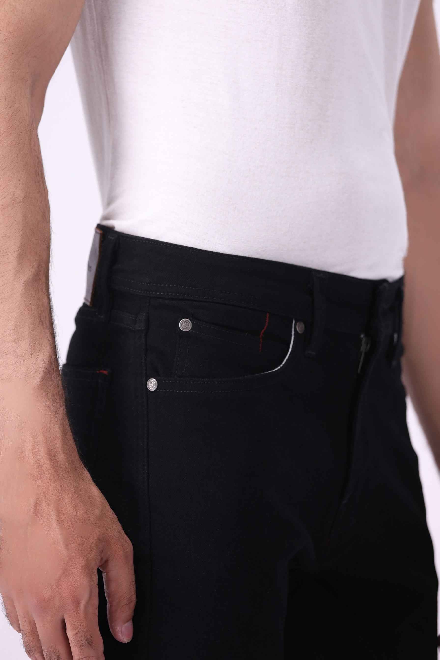 Close-up front view of Medved black jeans highlighting the high-performance stretch and durable denim texture.